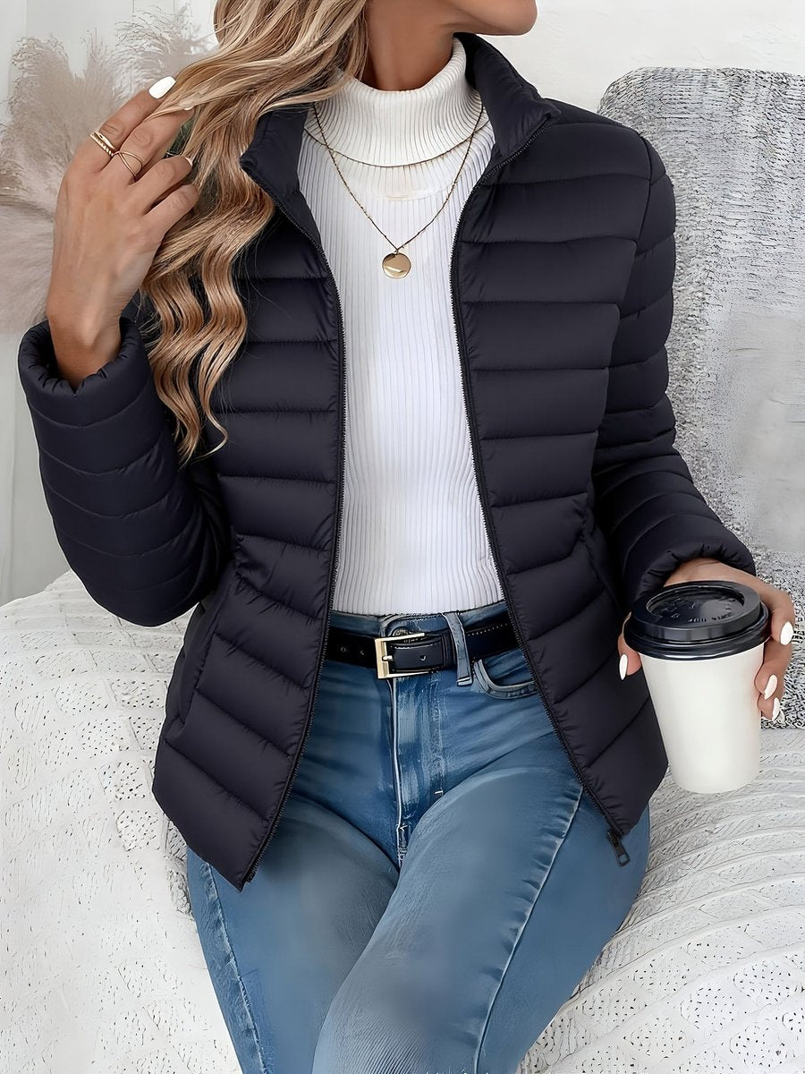 Women's lightweight quilted puffer coat by Christine Brewer with stand collar and front zip-up closure.