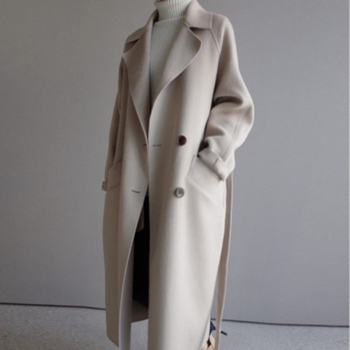 Women's long double-breasted wool-blend trench coat in a longline style by Christine Brewer, shown on a model.