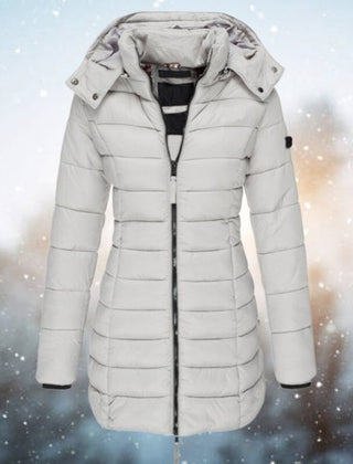 Women’s long quilted hooded puffer coat by Christine Brewer, featuring a zip-up winter jacket with a cozy hood and quilted design.