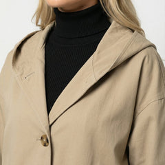 Olivia women's long waterproof hooded trench coat by Christine Brewer, shown in dark color, with a belt and hood for rain protection.