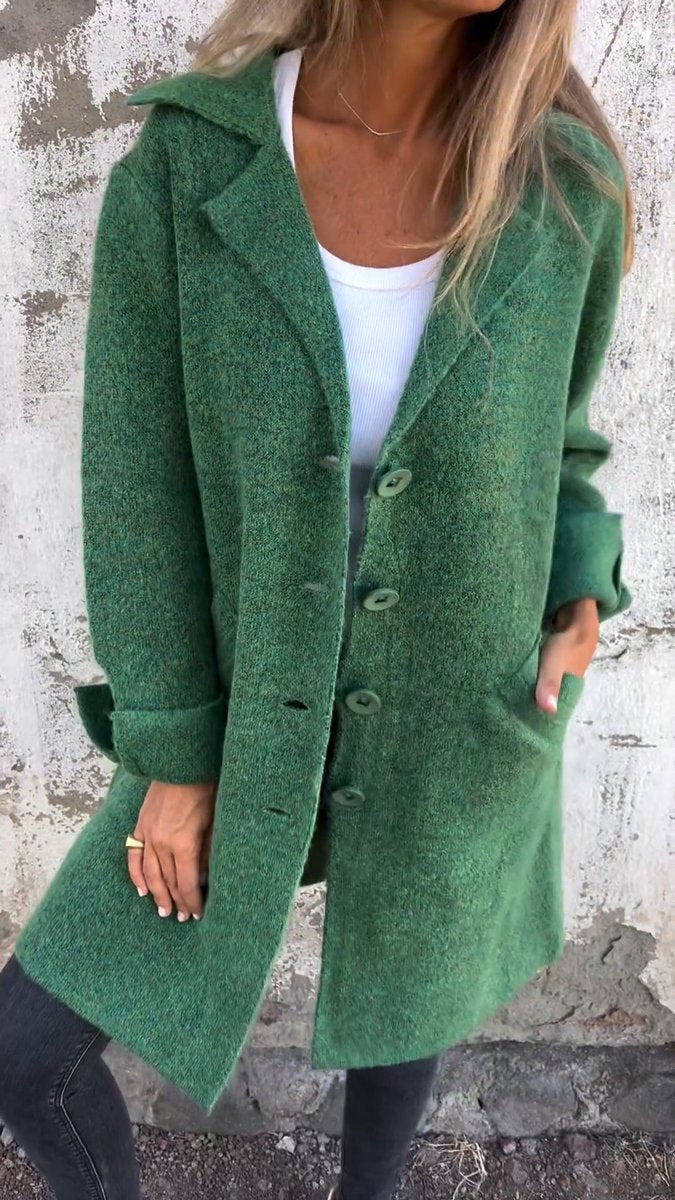 Women's longline button-up coat with lapel collar and oversized fit by Christine Brewer, shown hanging with open front and classic style.
