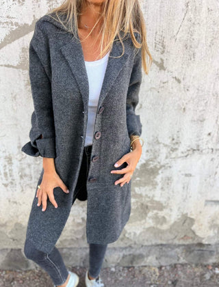 Women's longline button-up coat with lapel collar in an oversized fit by Christine Brewer, shown on a model.