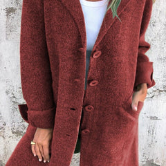 Women's longline button-up coat with lapel collar and oversized fit by Christine Brewer, shown on a model.