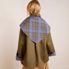 Women's oversized double-breasted trench coat with tartan lining and collar by Christine Brewer, shown on a model.