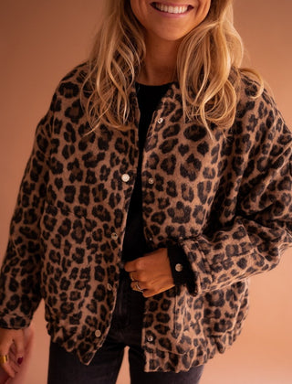 Women's oversized leopard print quilted jacket with snap buttons by Christine Brewer, featuring bold animal print and cozy design.