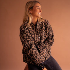 Women's oversized leopard print quilted jacket with snap buttons by Christine Brewer, featuring bold animal print and cozy quilted design.