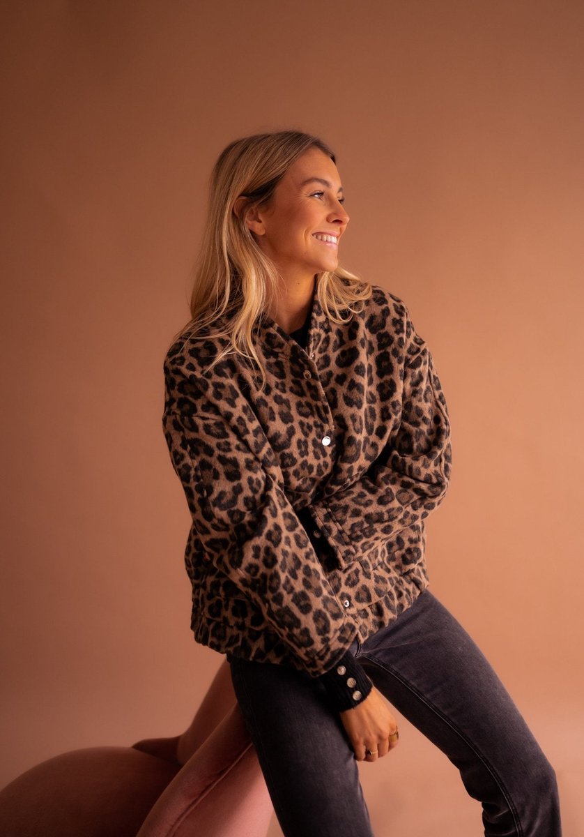 Women's oversized leopard print quilted jacket with snap buttons by Christine Brewer, featuring bold animal print and cozy quilted design.