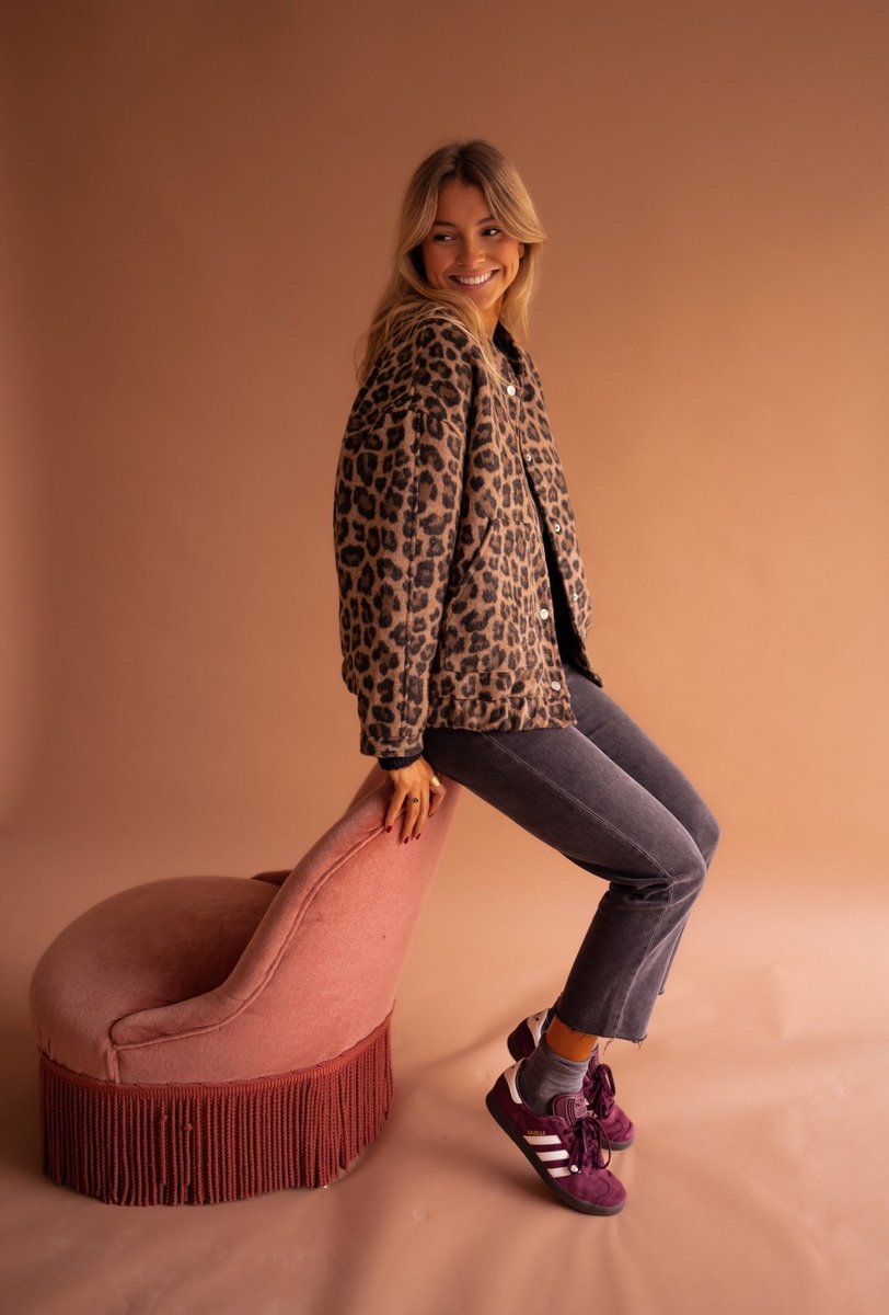 Women's oversized leopard print quilted jacket with snap buttons by Christine Brewer, featuring bold animal print and cozy quilted design.