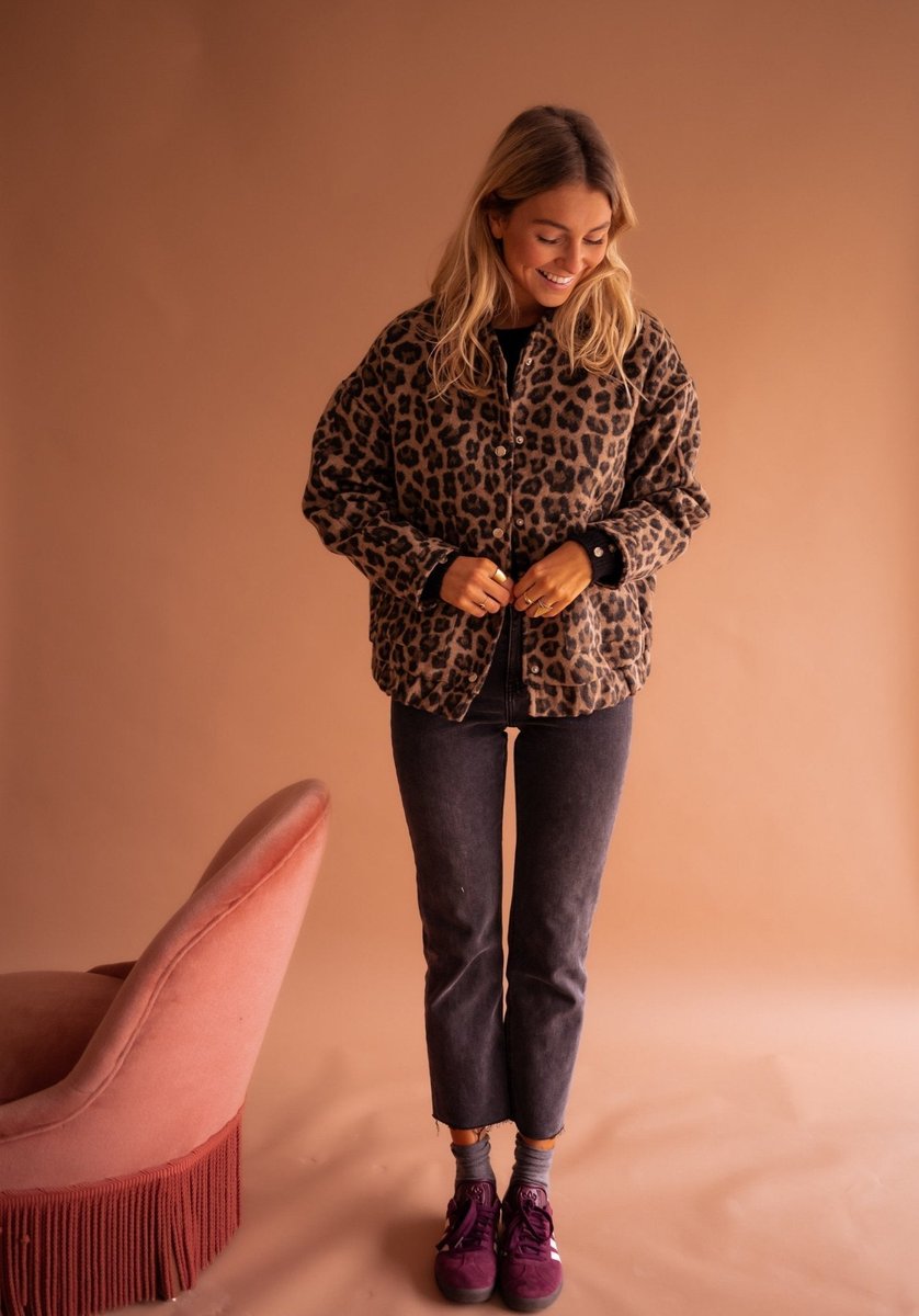 Women's oversized leopard print quilted jacket with snap buttons by Christine Brewer, featuring bold animal print and cozy quilted design.