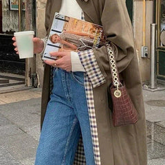 Women's oversized trench coat by Christine Brewer with plaid lining, cotton blend fabric, and classic trench design.