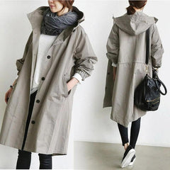 Women's oversized water-resistant trench coat with button front in beige, designed by Christine Brewer, shown on a model.
