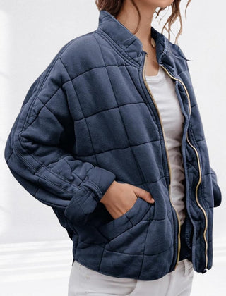 Women's relaxed-fit diamond quilted zip-up jacket by Christine Brewer, shown in a casual setting with front view.