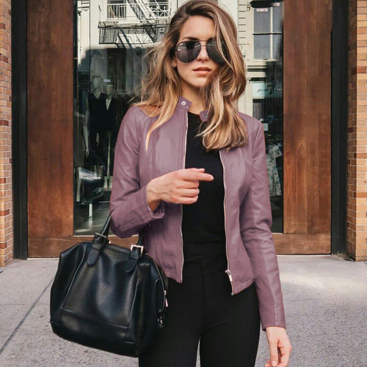 Women's slim-fit faux leather zip-up jacket by Christine Brewer, shown on a model with a stylish, fitted silhouette.