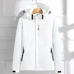 Women's waterproof hooded rain jacket by Christine Brewer with adjustable fit, shown in a stylish outdoor setting.